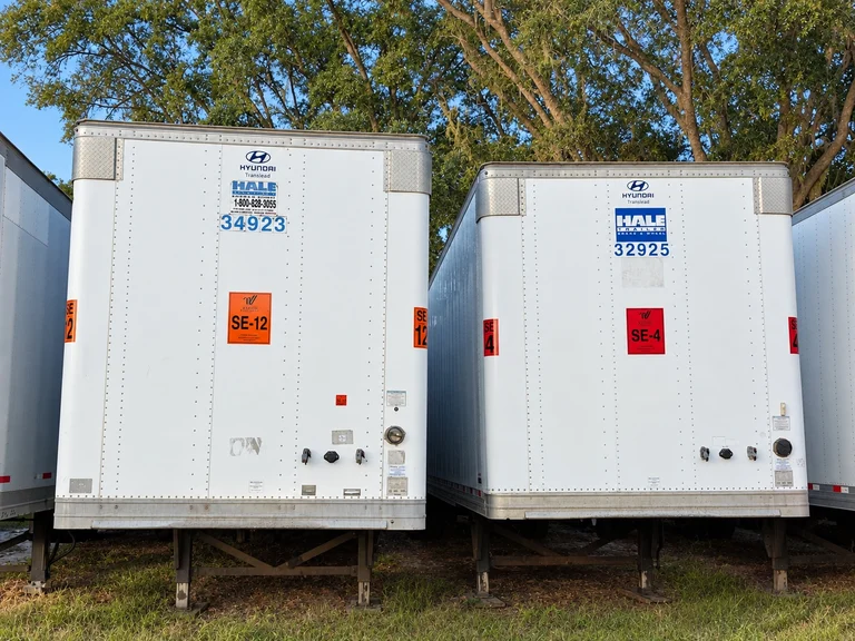 Two white trailers with orange SE-12 and red SE-4 Varsity Southeast decals installed